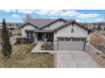 Charming stucco home featuring a two-car garage and stone accents on the front facade at 16500 Crosby Dr, Broomfield, CO 80023