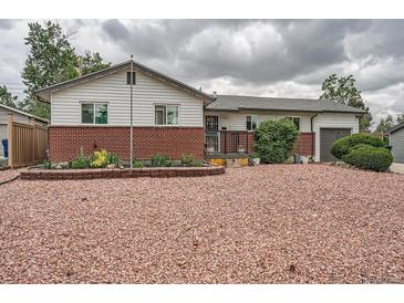 Charming ranch-style home with a brick accent and a well-maintained yard filled with decorative pink crushed gravel at 6346 Fenton St, Arvada, CO 80003
