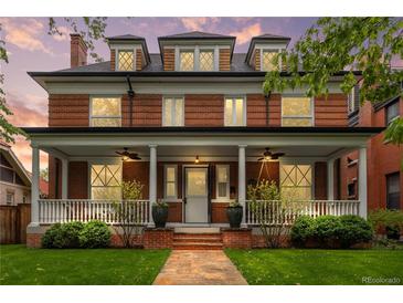 Charming two-story red brick home with a welcoming front porch and meticulously maintained landscaping at 963 N Lafayette St, Denver, CO 80218