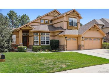 Charming two-story home featuring a three-car garage, landscaped yard, and inviting curb appeal at 14820 E Maplewood Dr, Centennial, CO 80016