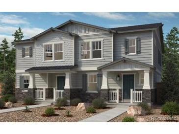 Charming townhouse with gray siding, stone accents, and inviting covered porch at 5231 N Elk St, Aurora, CO 80019