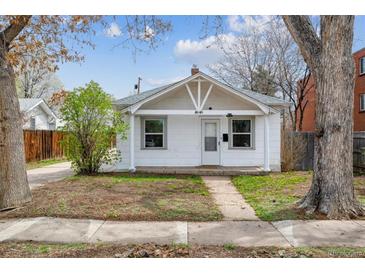 Charming white bungalow with classic architectural details and a cozy front yard at 4046 S Bannock St, Englewood, CO 80110