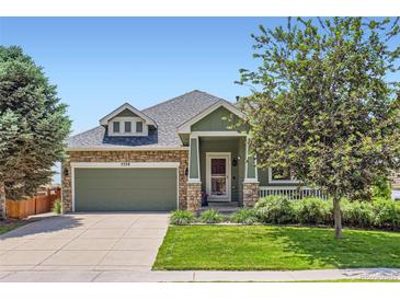 Charming home featuring a stone-accented facade, lush lawn, and well-manicured landscaping at 5328 Potentilla St, Brighton, CO 80601