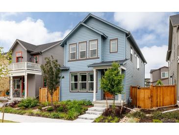 Charming two-story home with blue siding, brown trim, and a well-manicured front yard in a suburban neighborhood at 10025 E 63Rd Ave, Denver, CO 80238