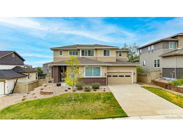 Inviting two-story home boasts a well-maintained lawn, charming brick accents, and an attached two-car garage at 4145 Manorbrier Cir, Castle Rock, CO 80104