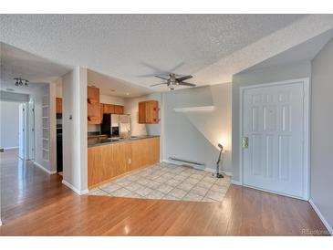 Inviting living room featuring an open kitchen, and stylish tile flooring, ideal for modern living at 14780 E Kentucky Dr # 432, Aurora, CO 80012