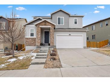 Charming two-story home featuring stone accents, gray siding, concrete driveway, and attached two-car garage at 3980 Trail Stone Cir, Castle Rock, CO 80108