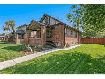 Charming brick home featuring a well-manicured lawn and inviting front porch at 2740 N Fillmore St, Denver, CO 80205