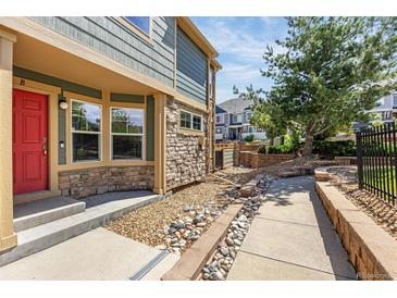 Charming home exterior featuring a red front door, stone accents, and manicured landscaping at 23560 Alamo Pl # B, Aurora, CO 80016