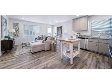 Open concept kitchen and living area with stainless steel appliances and light flooring at 45032 Sunflower Ln, Bennett, CO 80102