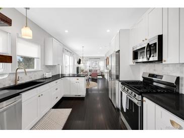 Modern kitchen features white cabinets, black countertops, and stainless steel appliances at 1402 Meade St, Denver, CO 80204