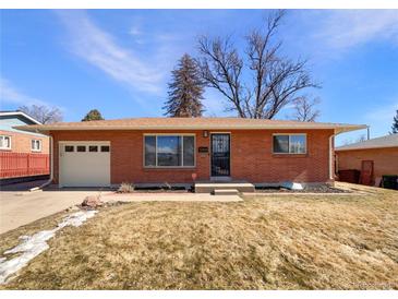 Charming brick home featuring an attached garage, landscaped yard, and classic architectural details at 3268 S Patton Ct, Denver, CO 80236