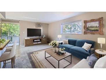 Bright living room featuring a plush blue sofa, large window, and stylish decor creating a cozy atmosphere at 937 N Clarkson St # 206, Denver, CO 80218