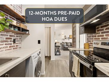 Kitchen features brick walls, marble countertops, and modern appliances, including a washer/dryer at 3035 Oneal Pkwy # 36T, Boulder, CO 80301