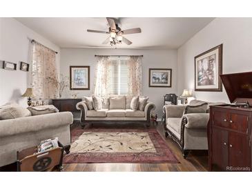 Comfortable living room featuring neutral furniture, hardwood floors, ceiling fan, and natural light at 7514 Blue Water Dr, Castle Rock, CO 80108