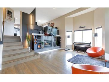 Open living room with fireplace and soaring ceilings, offering abundant natural light and stylish decor at 14058 E Temple Dr, Aurora, CO 80015