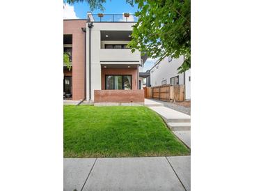 Modern two-story home featuring a red brick facade, white accents, a well-manicured lawn and an inviting front terrace at 2244 S Lincoln St, Denver, CO 80210