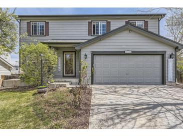 Charming gray two-story home with attached garage and manicured front yard is ideal for Gathering living at 5316 S Rome St, Aurora, CO 80015