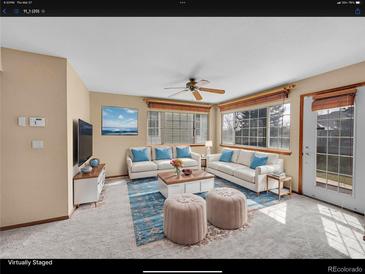 Bright living room features plush seating, area rug, and large windows at 18736 E Powers Pl, Aurora, CO 80015