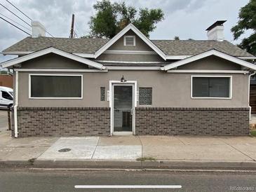 Charming single-story exterior showcasing a brick foundation and a symmetrical front façade with large windows at 421 E Alameda Ave, Denver, CO 80209