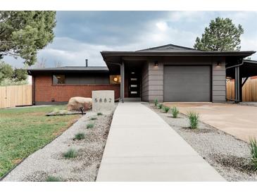 Charming single-story home with a well-manicured front yard and a modern concrete walkway at 5882 W Chestnut Ave, Littleton, CO 80128