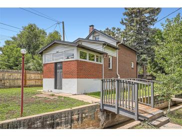 Quaint brick home featuring charming architectural details and a small bridge leading to the entrance at 3655 Zenobia St, Denver, CO 80212