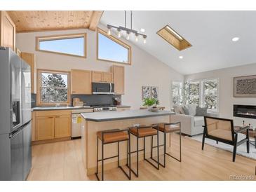 Bright, open kitchen featuring light wood cabinets, island seating, and vaulted ceilings at 342 Brook Cir, Boulder, CO 80302
