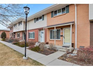 Charming townhome with a brick facade, sidewalk, and well-maintained landscaping creates a welcoming curb appeal at 9207 E Mansfield Ave, Denver, CO 80237