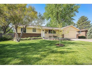 Charming one-story home featuring a well-maintained lawn, mature trees, and an inviting front porch at 8626 W Utah Ave, Lakewood, CO 80232