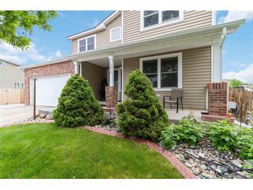 Charming home featuring a well-manicured lawn, tidy landscaping, and attractive brick accents at 10870 Crestone Needles Dr, Parker, CO 80138