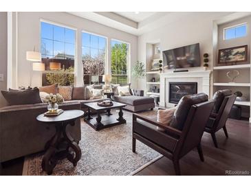 Bright living room features large windows, fireplace, and hardwood floors at 6970 E Lake Dr, Centennial, CO 80111