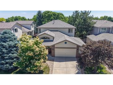 Charming two-story home featuring a well-maintained lawn, mature trees, and a two-car garage at 10532 Madison St, Thornton, CO 80233