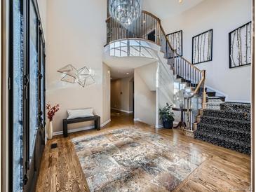 Grand foyer featuring a curved staircase, chandelier, and decorative tiled entryway at 18971 E Pinewood Dr, Aurora, CO 80016