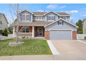 Charming two-story home featuring a brick facade, a covered porch and an attached garage at 20567 E Weaver Dr, Aurora, CO 80016