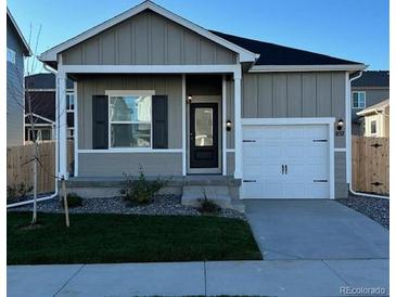 Charming single-story home featuring a well-manicured lawn and an attached two-car garage, enhancing curb appeal at 857 Sawdust Dr, Brighton, CO 80601