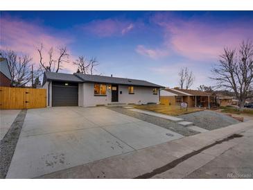 Ranch style home with a newly paved driveway and modern gray garage door at 1061 Elbert St, Denver, CO 80221