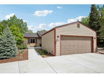 Charming single-story home with a two-car garage and well-maintained landscaping with concrete driveway and walkway at 912 Oakwood Dr, Castle Rock, CO 80104