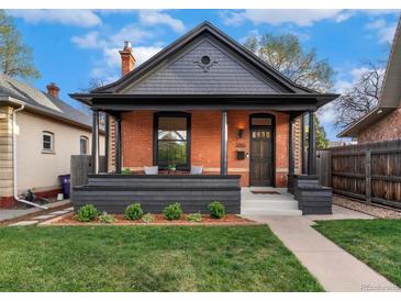 Charming brick home with a covered front porch, dark trim, and beautifully manicured lawn at 2930 W 34Th Ave, Denver, CO 80211