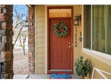 Inviting front door with a decorative wreath and a colorful 'Welcome' mat at 11230 Osage Cir # B, Northglenn, CO 80234