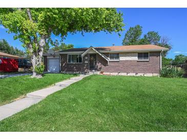 Charming brick home with a lush green lawn and mature trees, perfect for curb appeal at 8250 Chase Way, Arvada, CO 80003