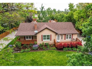 Charming single Gathering home featuring a covered front porch and beautifully landscaped front yard at 7785 W 5Th Ave, Lakewood, CO 80226