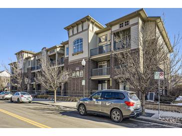 Apartment building featuring brick accents, balconies, and well-maintained landscaping on a clear day at 3852 S Dallas St # 8-308, Aurora, CO 80014