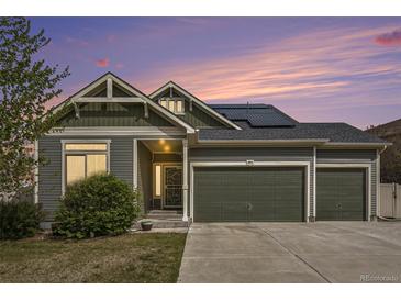 Charming two-story home featuring a three-car garage and well-manicured lawn at sunset at 4873 Cathay Ct, Denver, CO 80249