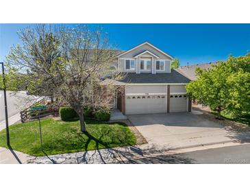 Beautiful two-story home with a three-car garage, lush lawn and mature shade tree at 7506 Chipmunk Pl, Littleton, CO 80125