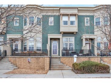 Inviting two-story townhome featuring a quaint front porch, updated paint, and a welcoming entrance at 9369 Longs Peak Dr, Henderson, CO 80640