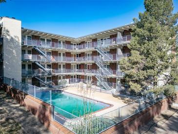 Bright aerial view of the community pool surrounded by the building's apartments, offering a refreshing amenity for residents at 33 N Corona St # 205, Denver, CO 80218