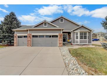 Charming gray two-story home featuring a three-car garage, brick accents, and well-kept landscaping at 2347 Switch Grass Way, Castle Rock, CO 80109