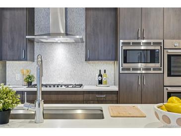 Modern kitchen featuring stainless steel appliances, gray cabinets, backsplash and a stylish countertop at 250 Columbine St # 310, Denver, CO 80206