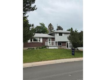Charming two-story home with brick and siding, features a well-manicured lawn and inviting curb appeal at 3566 E Fair Pl, Centennial, CO 80121