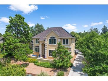 Inviting two-story home with lush landscaping, a pathway, and an arched entryway, creating an elegant and welcoming curb appeal at 1564 S Uinta Way, Denver, CO 80231